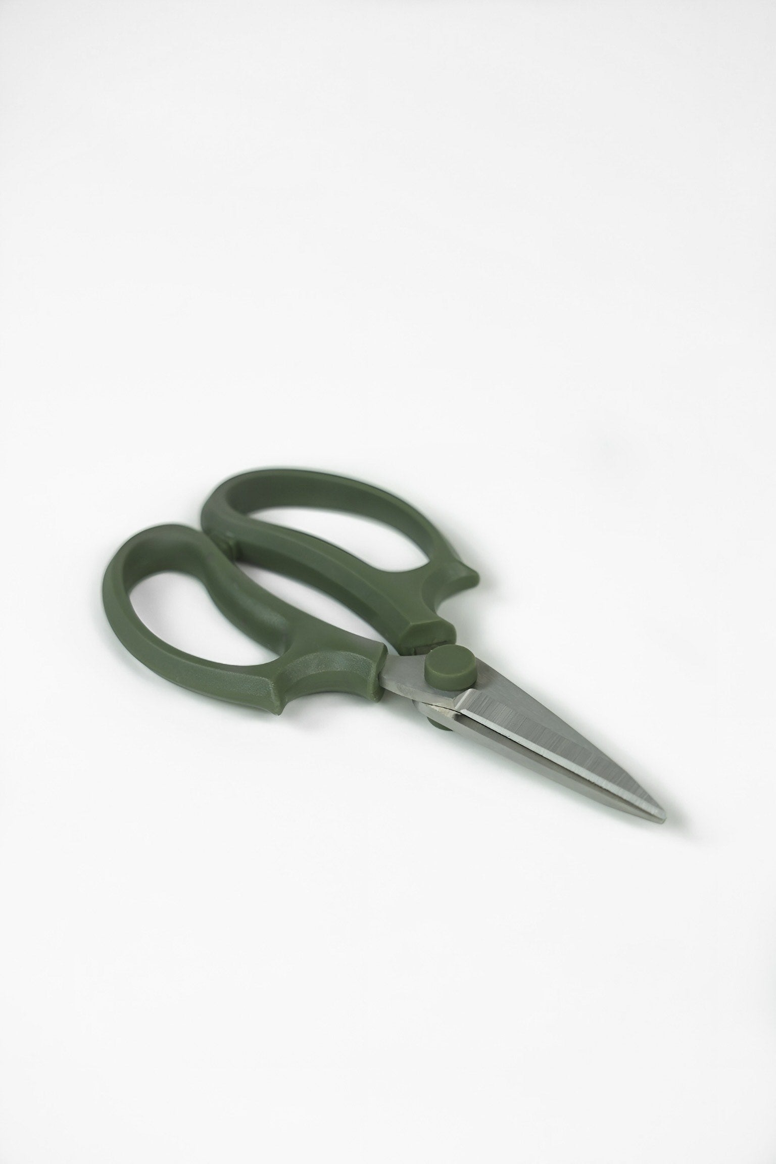 Green scissors on a white background
