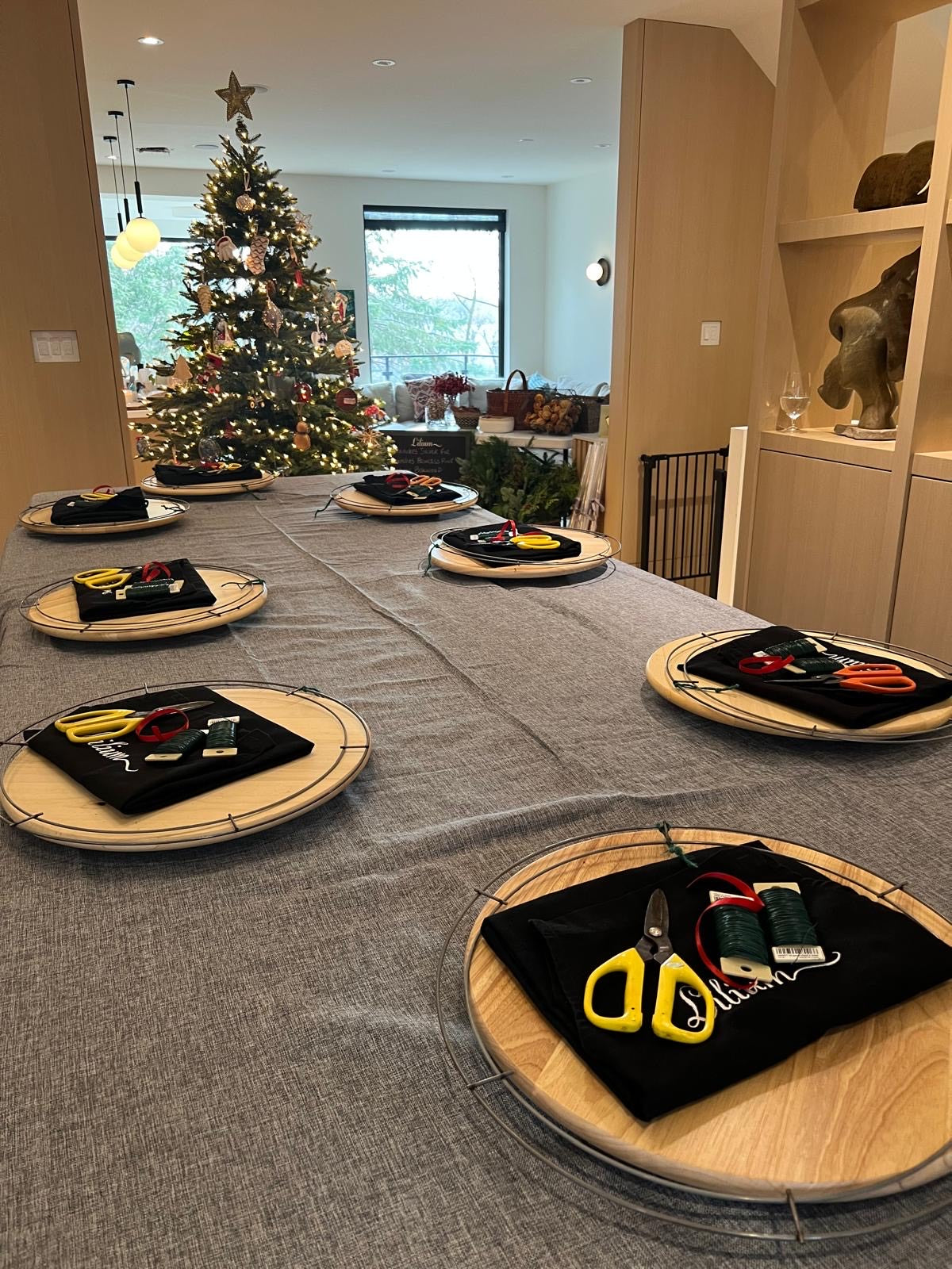 Dining table set for a Christmas dinner with decorative items on each place setting.